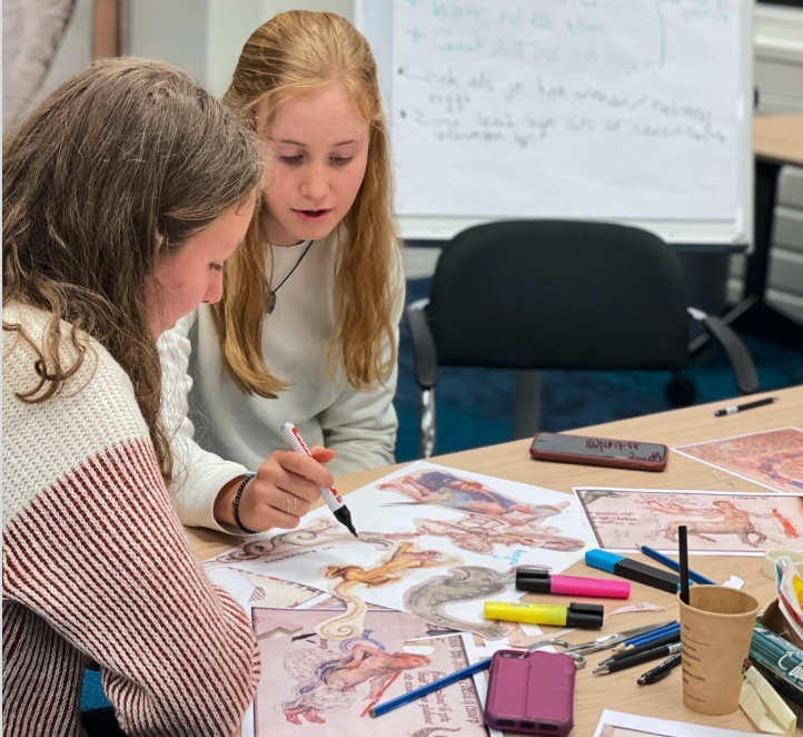 Students playing (drawing, cutting and pasting) with printed pictures from the medieval manuscript