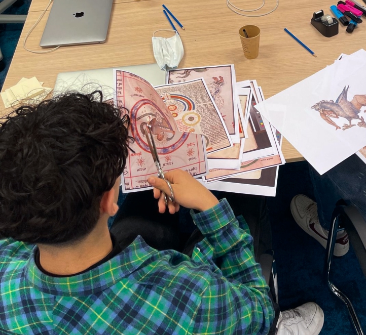 Students playing (drawing, cutting and pasting) with printed pictures from the medieval manuscript